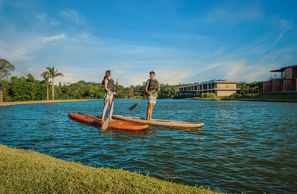casal fazendo stand-up paddle no Clara Dourado