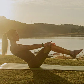 mulher praticando atividade física ao ar livre próximo ao lago no resort ao entardecer
