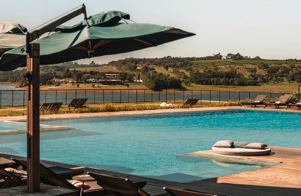 área externa do Clara Ibiúna Resorts com vista para a piscina e o lago
