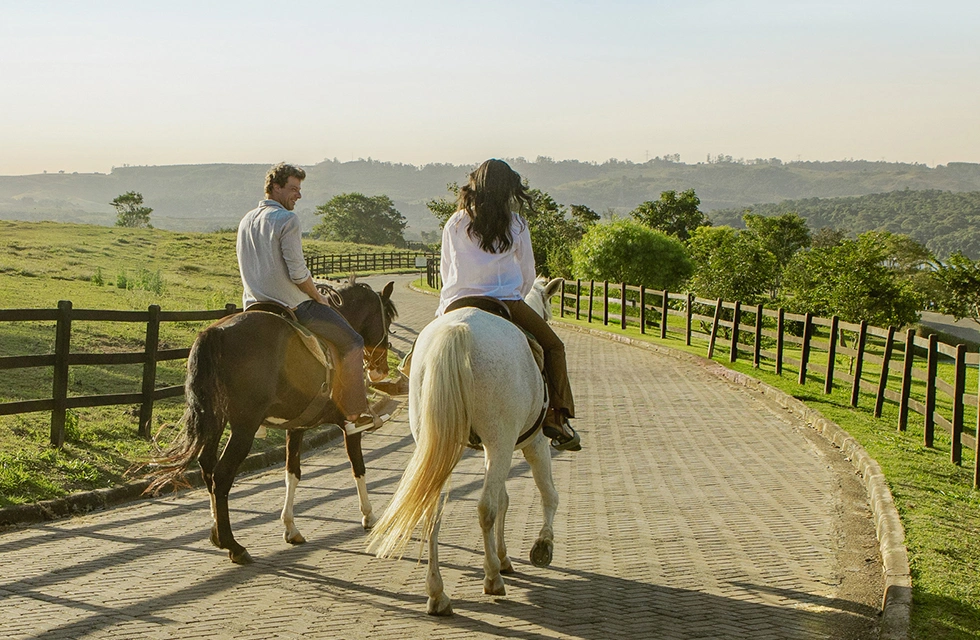 casal andando a cavalo no Clara Ibiúna, curtindo linda paisagem