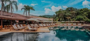 vista da piscina externa com espreguiçadeiras e guarda-sol