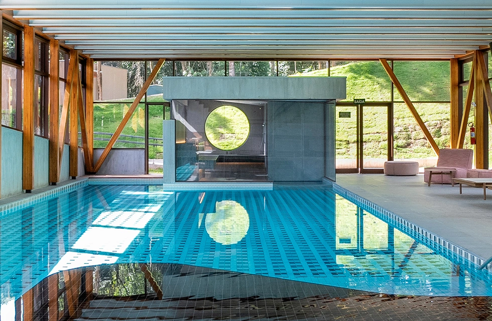vista da área interna do Clara Arte, com piscina aquecida, sauna e um espaço agradável para relaxar